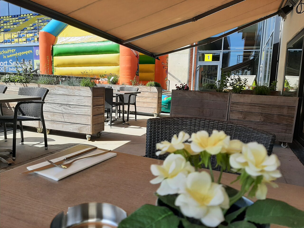 Terras met bloemen en springkasteel